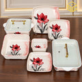 Glamour red floral square plates, bowls and clear-lidded serving dishes are arranged on a wooden table.