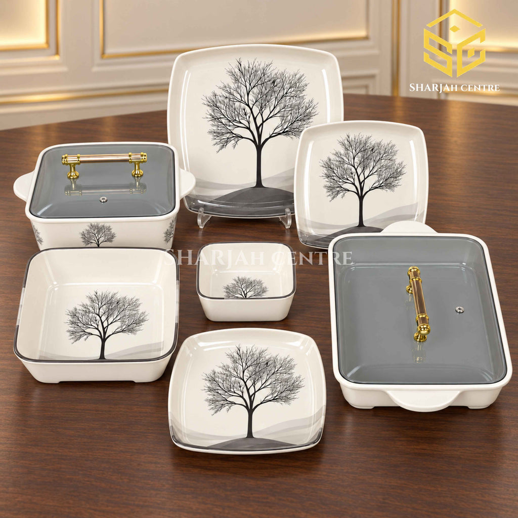 Glamour Black Tree plates, bowls and covered serving dishes with gold-tone handles are displayed on a wooden table.