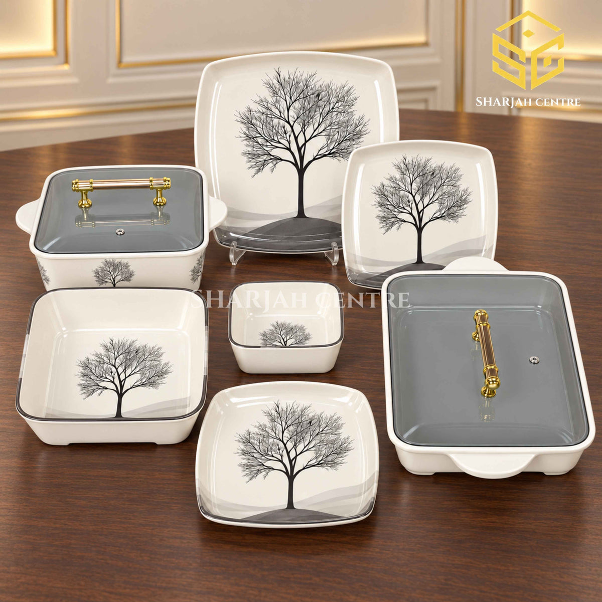 Glamour Black Tree plates, bowls and covered serving dishes with gold-tone handles are displayed on a wooden table.