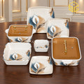 Glamour square dinnerware with white lily flowers, blue accents and amber-lidded serving dishes is arranged against a white background.
