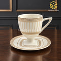 ivory white cup and saucer, gold lattice pattern, pedestal tea cup, luxury wooden table setting, Sharjah Centre Multan