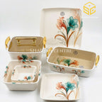 Modern teal and peach floral dinnerware is displayed against a white background with matching square bowls and an open serving dish.